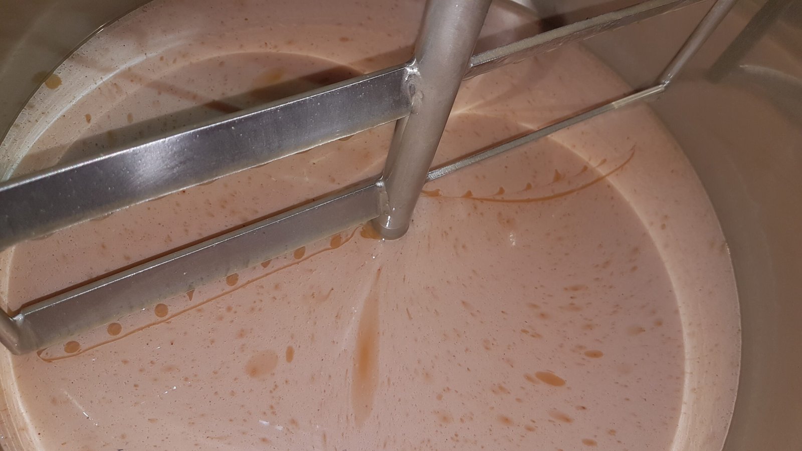 Raw honey part-way through creaming in our stainless steel tank, the paddle steering the crystals